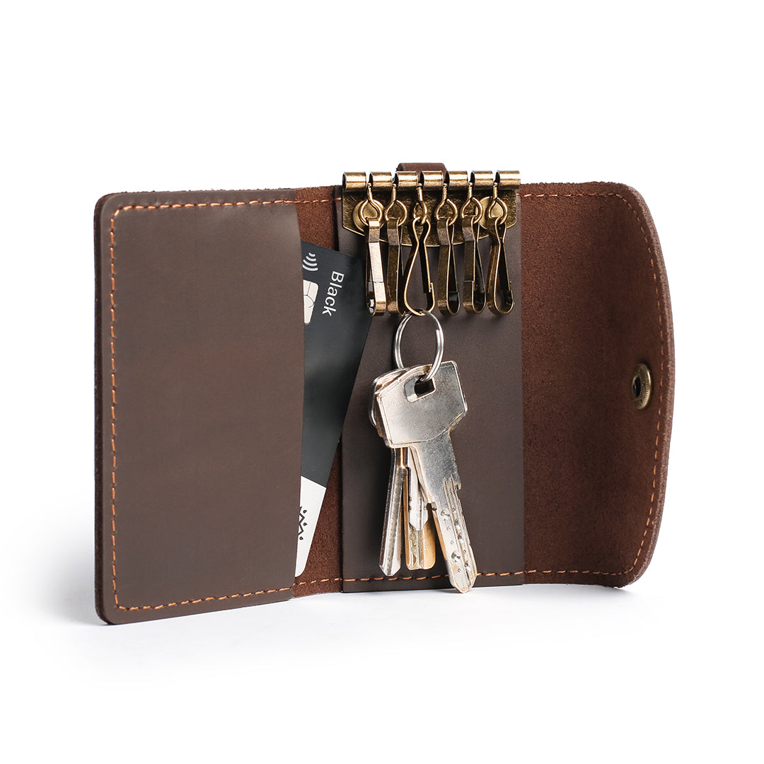 Open handmade leather key case with key hooks, attached keys, and a card slot, crafted from premium brown leather.