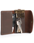 Open handmade leather key case with key hooks, attached keys, and a card slot, crafted from premium brown leather.