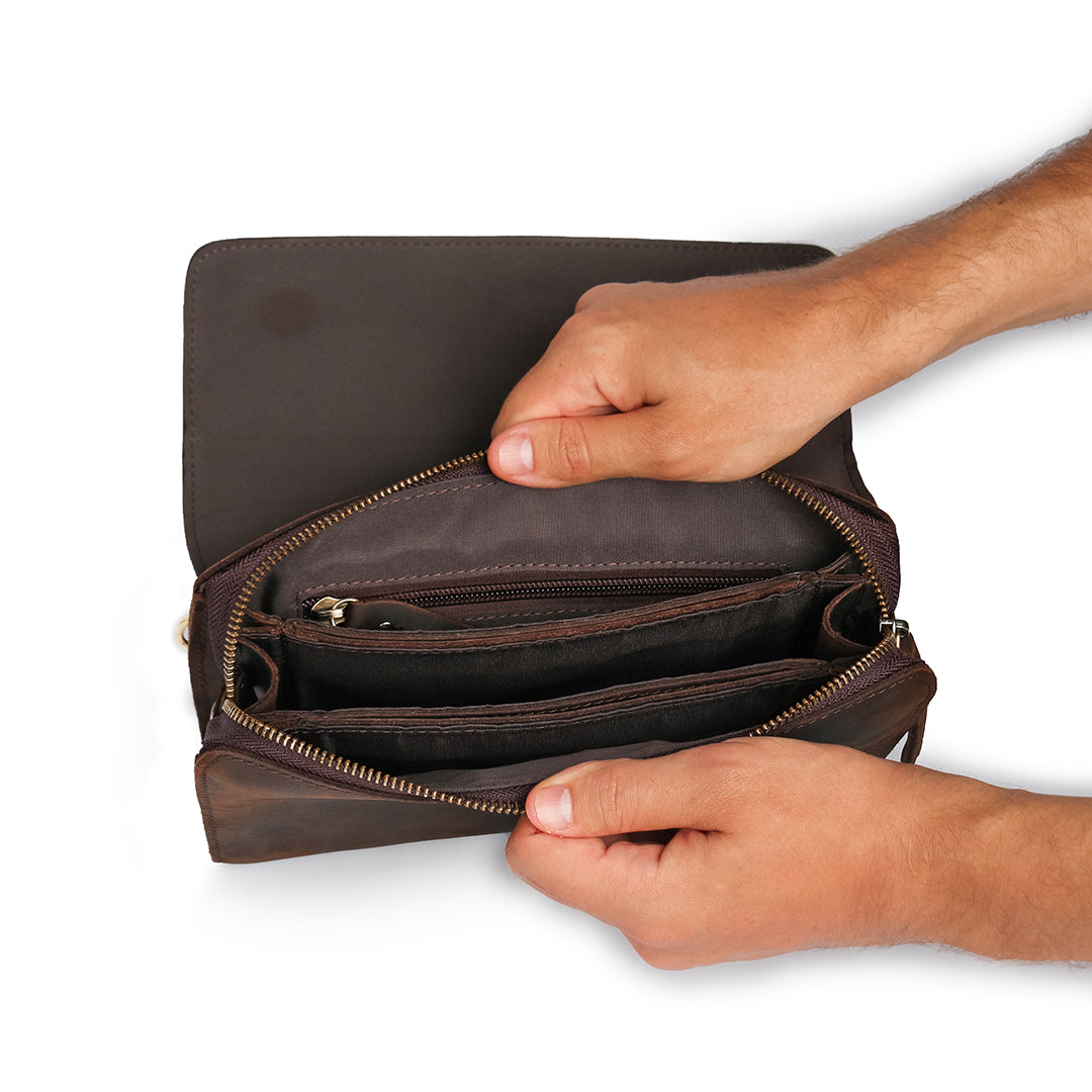 Open view of a dark brown leather wrist bag, revealing organized compartments and multiple pockets for optimal storage.