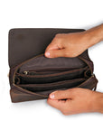 Open view of a dark brown leather wrist bag, revealing organized compartments and multiple pockets for optimal storage.