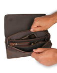 Interior of a men's dark brown leather clutch filled with accessories, showcasing its practicality and spacious compartments.