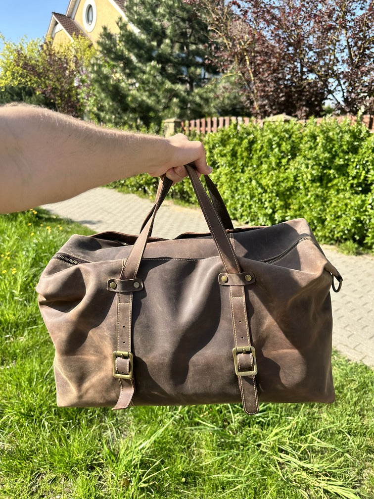 Outdoor shot of durable brown leather duffle bag, combining vintage design and spacious interior for everyday use