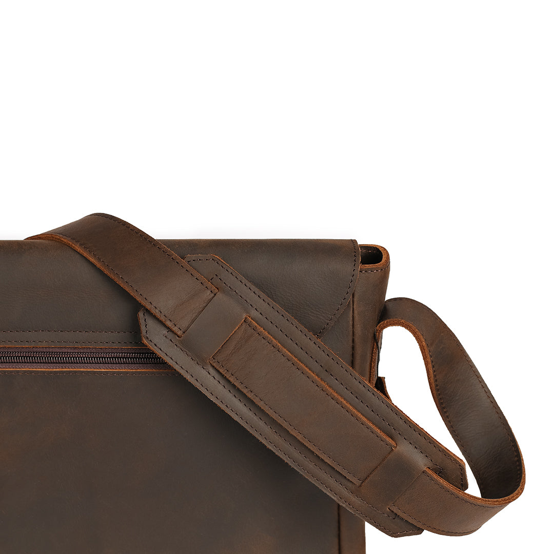 Sturdy padded shoulder strap of a brown leather satchel designed for comfortable everyday wear