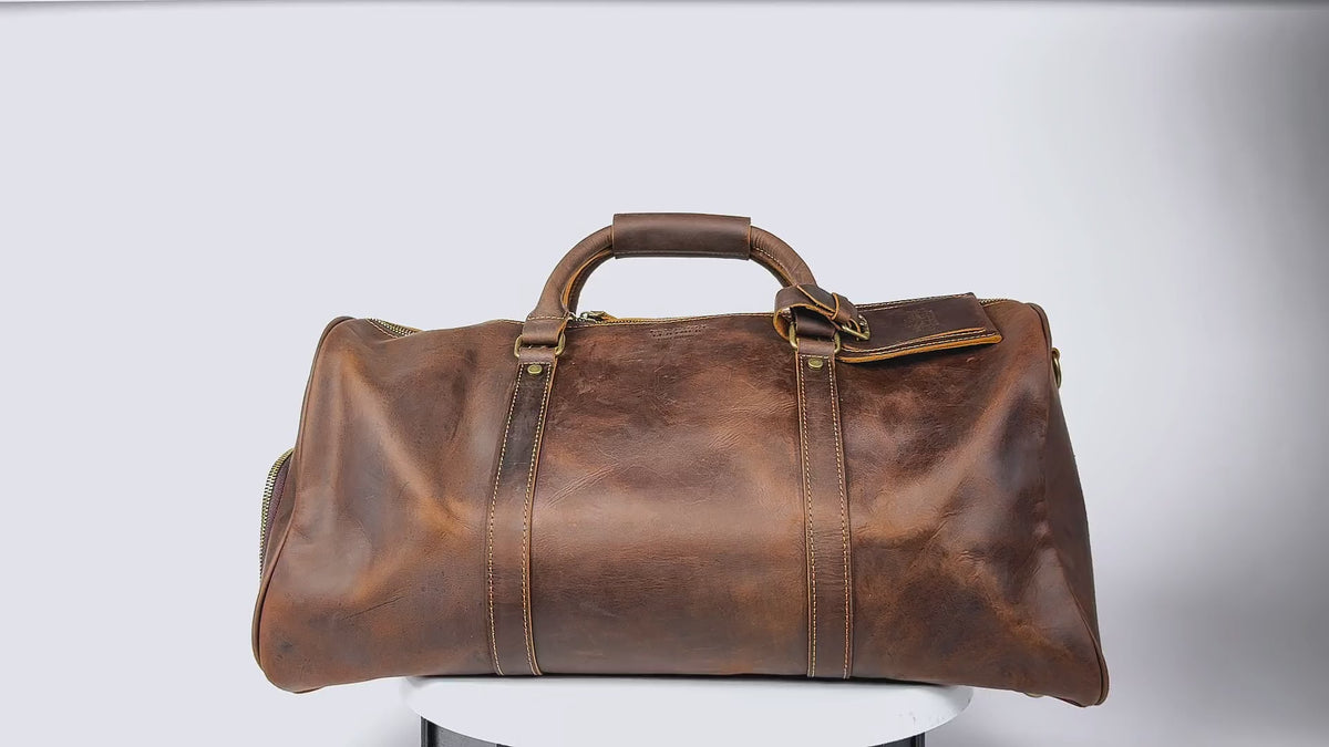 Brown leather duffle bag with shoe compartment, rotating to showcase its exterior and quality.