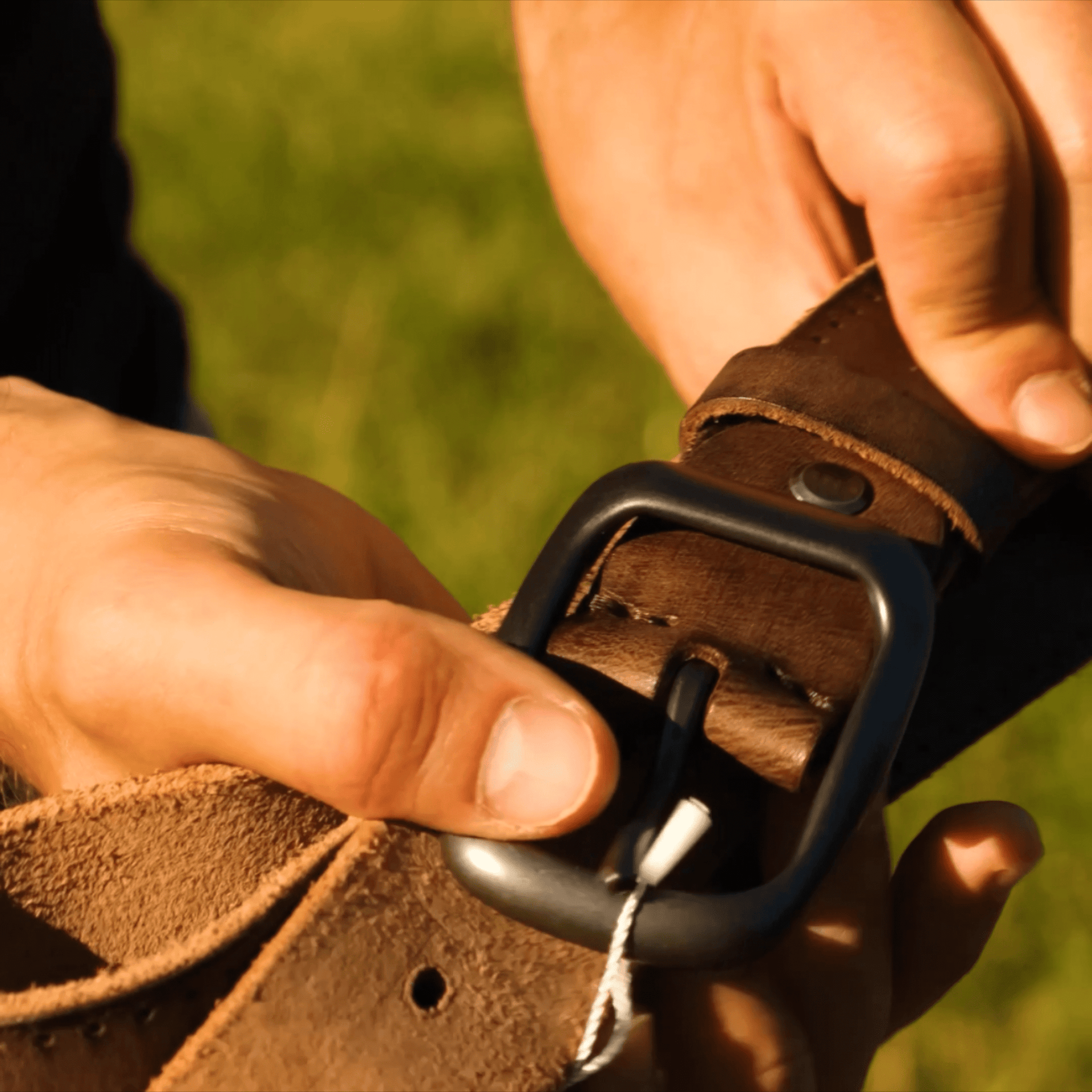 Unboxing a handcrafted brown leather belt, highlighting the vintage buckle, smooth texture, and branded pouch packaging.