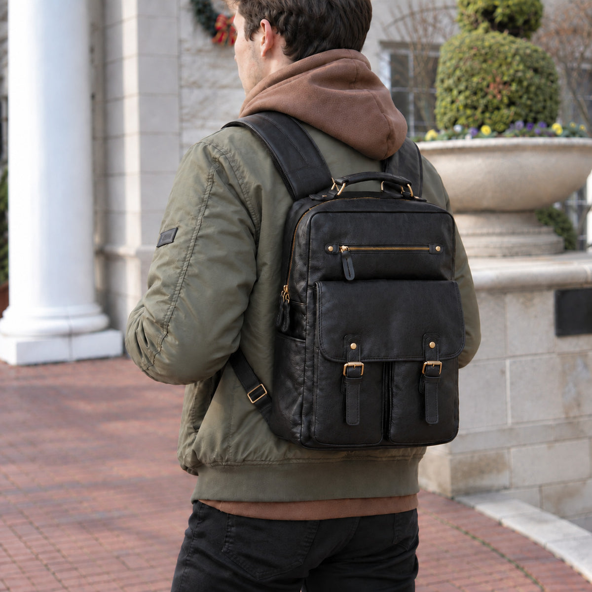 Professional black leather backpack for men with front buckle pockets, zip pocket, top handle and adjustable padded shoulder straps