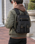 Professional black leather backpack for men with front buckle pockets, zip pocket, top handle and adjustable padded shoulder straps