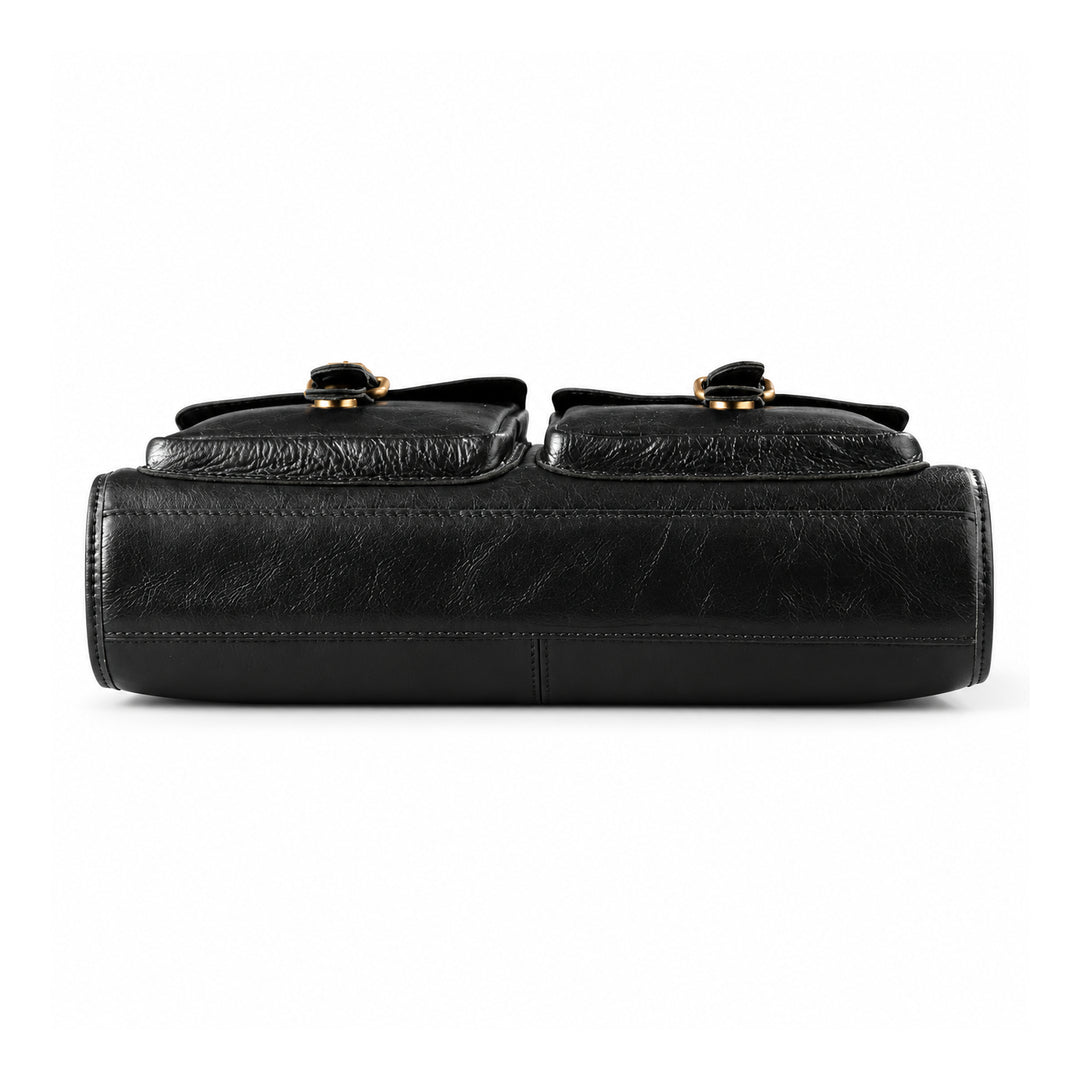 The bottom of a black leather briefcase shows a plain leather base, edge stitching and a central seam.