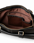The open black leather briefcase reveals brown lining, a zipped interior pocket and two leather-trimmed organizer pockets.