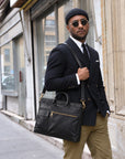 Professional black leather briefcase for men with top handles, adjustable shoulder strap and front zip pocket for business and work