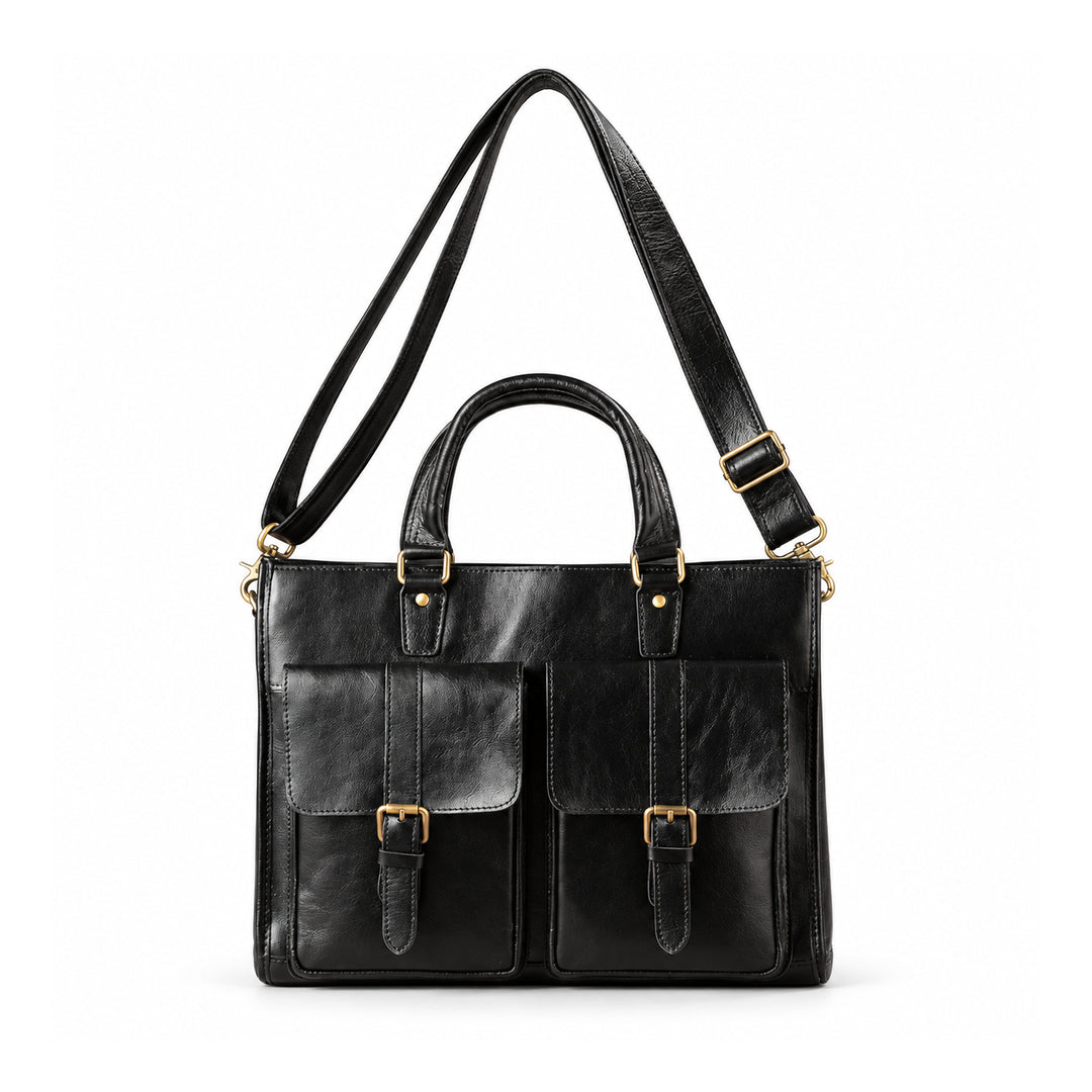 A black leather briefcase is shown with its adjustable shoulder strap extended above the twin carry handles.