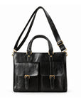 A black leather briefcase is shown with its adjustable shoulder strap extended above the twin carry handles.