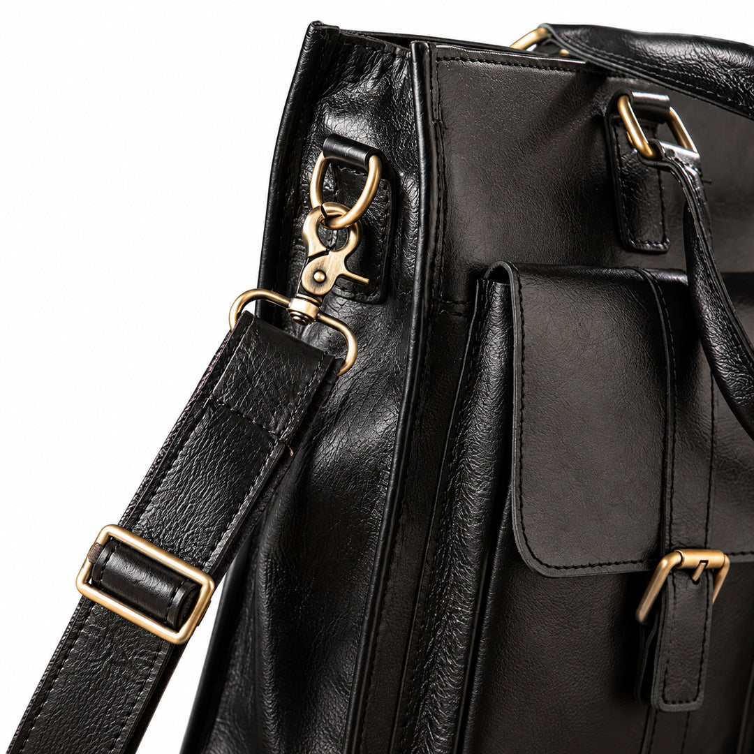 A close-up of the black leather briefcase shows the shoulder strap clasp, D-ring, adjustment buckle and stitching.