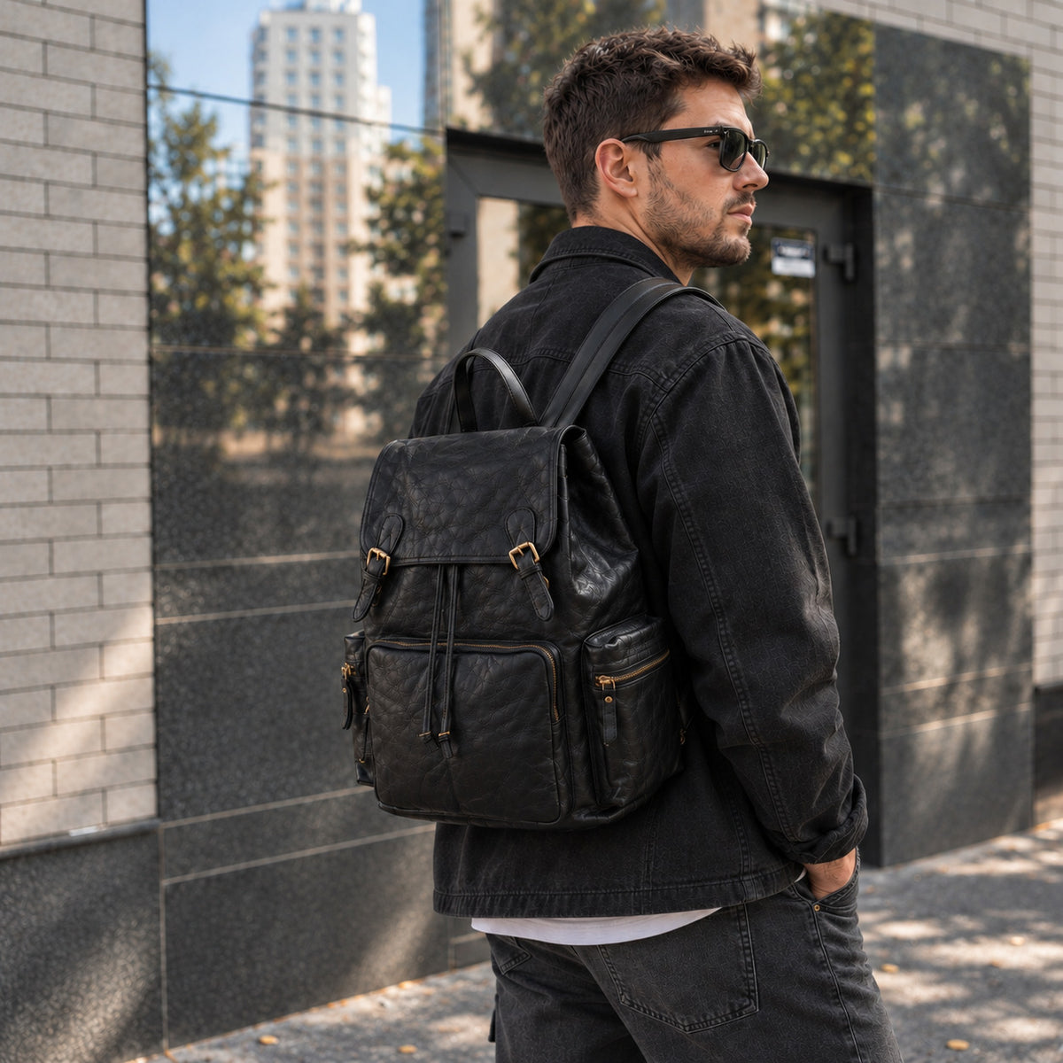 Quilted black leather backpack for men with flap top, buckle straps, drawstring closure and multiple exterior zip pockets