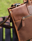Rear view of brown leather men's bag with detailed stitching and vintage zipper design.