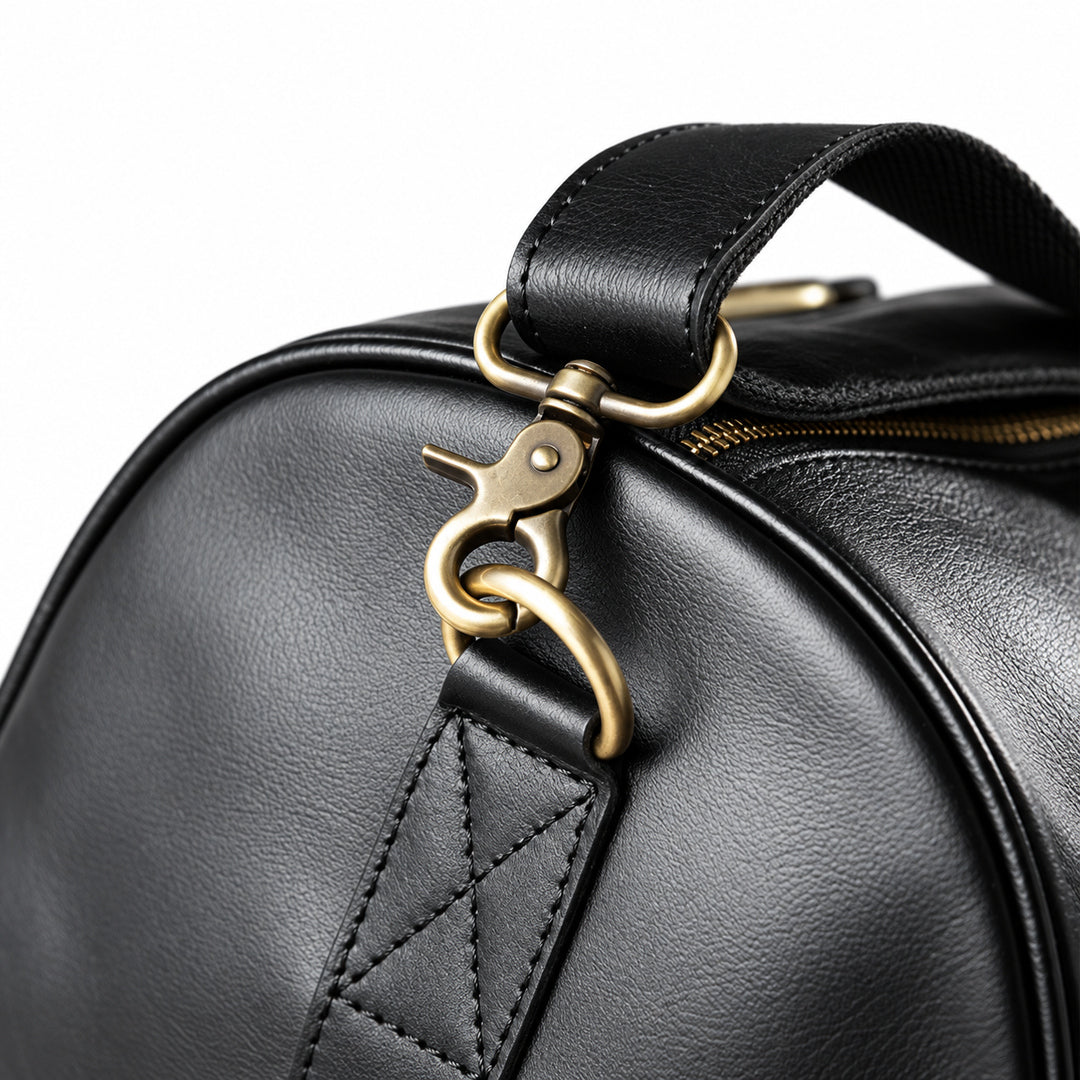 Refined black full-grain leather duffel bag strap clasp with a stitched leather attachment