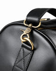 Refined black full-grain leather duffel bag strap clasp with a stitched leather attachment
