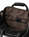 Refined black full-grain leather duffel bag interior with a zip pocket and brown fabric organizers