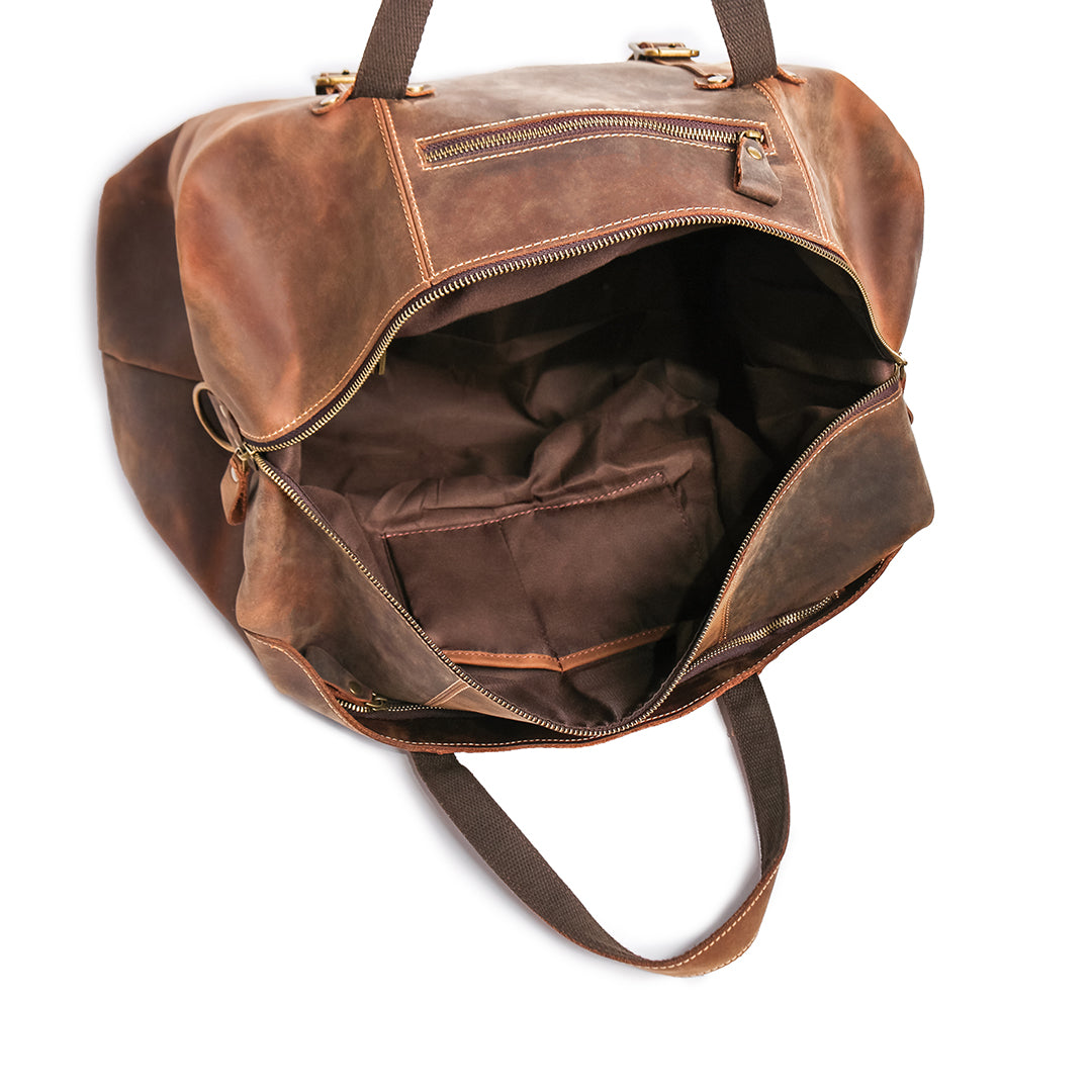 Close-up of reinforced brass rivets and stitching on vintage leather travel bag, ensuring durability and style.