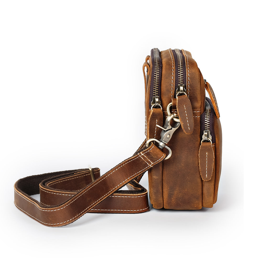 Brown leather crossbody bag with a strap on a white background