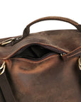 Close-up of the side pocket on a vintage leather backpack with a secure zipper, ideal for everyday or travel essentials.