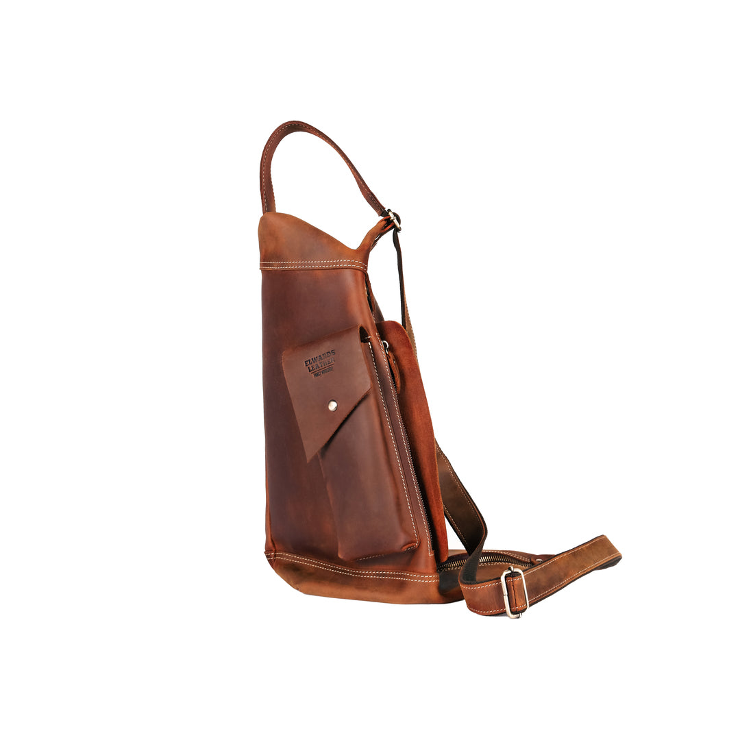 Side profile of a handmade crossbody leather bag made from top grain cowhide, featuring stitching and durable zippers.