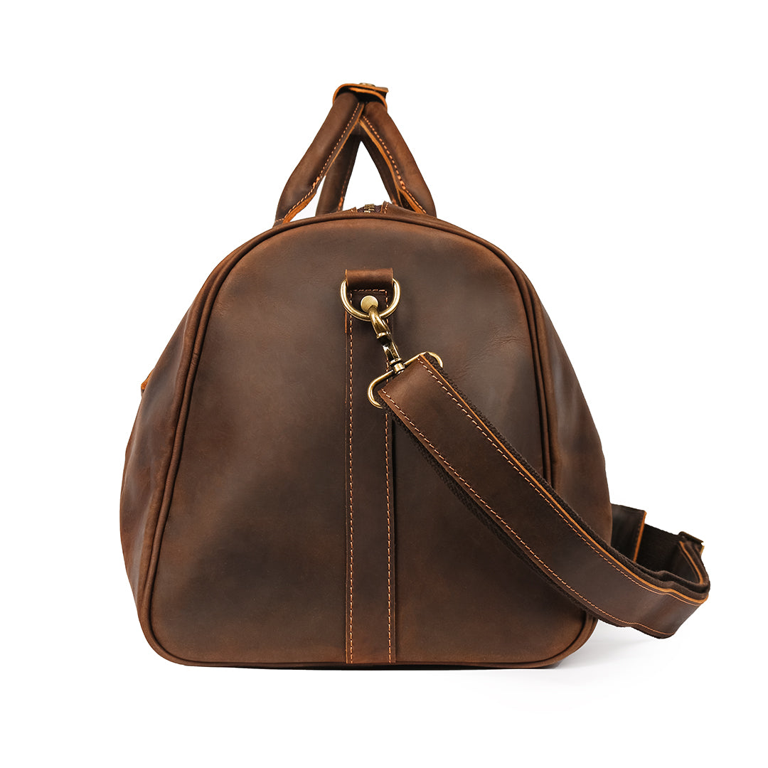 Side view of a brown Crazy Horse leather duffle bag with an attached adjustable strap for versatile carrying.