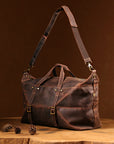 Side view of a vintage travel duffle bag, featuring durable Crazy Horse leather and spacious design for business trips.