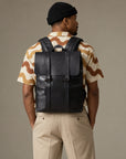 Sleek black leather backpack for men with flap top, dual front straps, zip pockets and padded shoulder straps