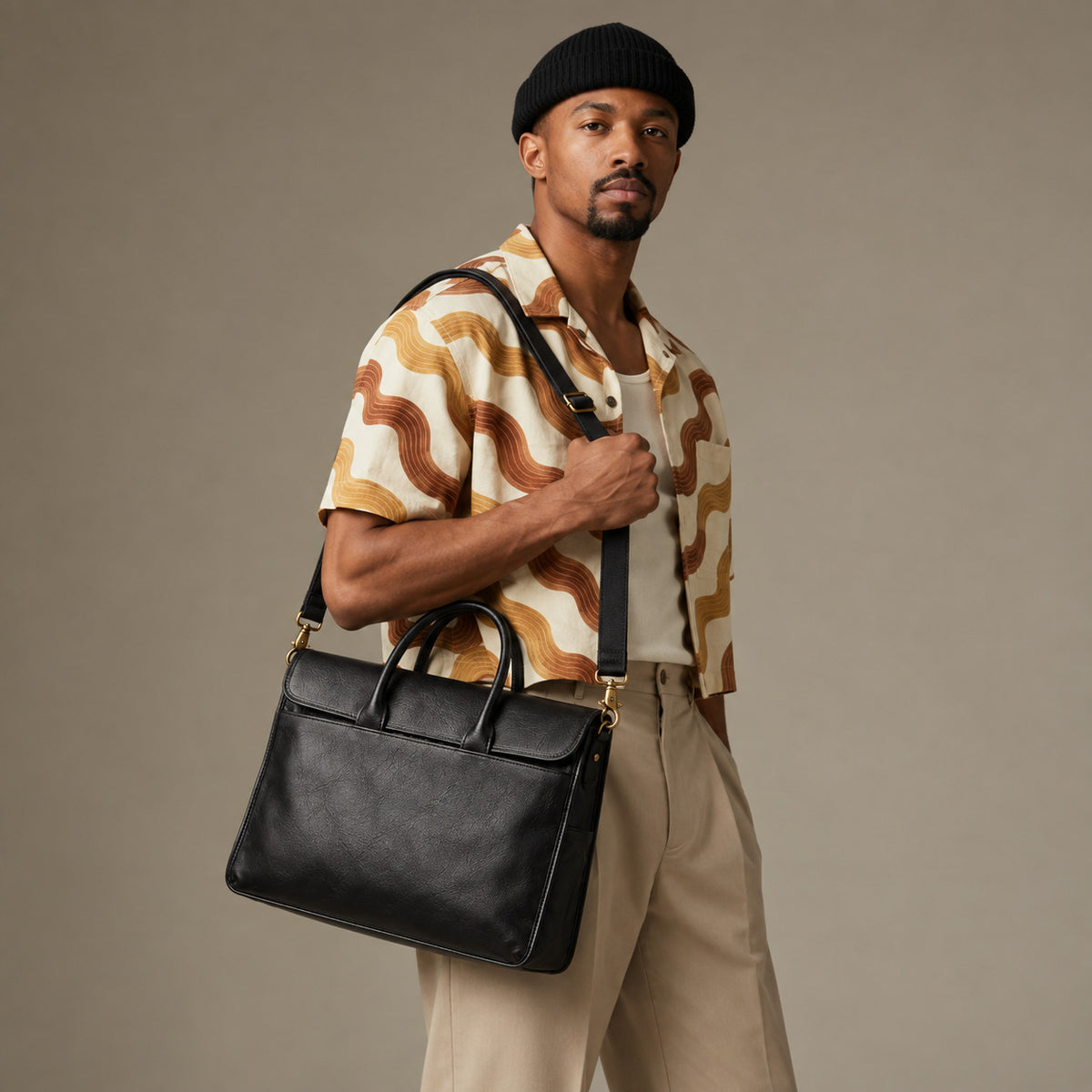 Slim black leather laptop briefcase for men with structured shape, dual carry handles and adjustable shoulder strap