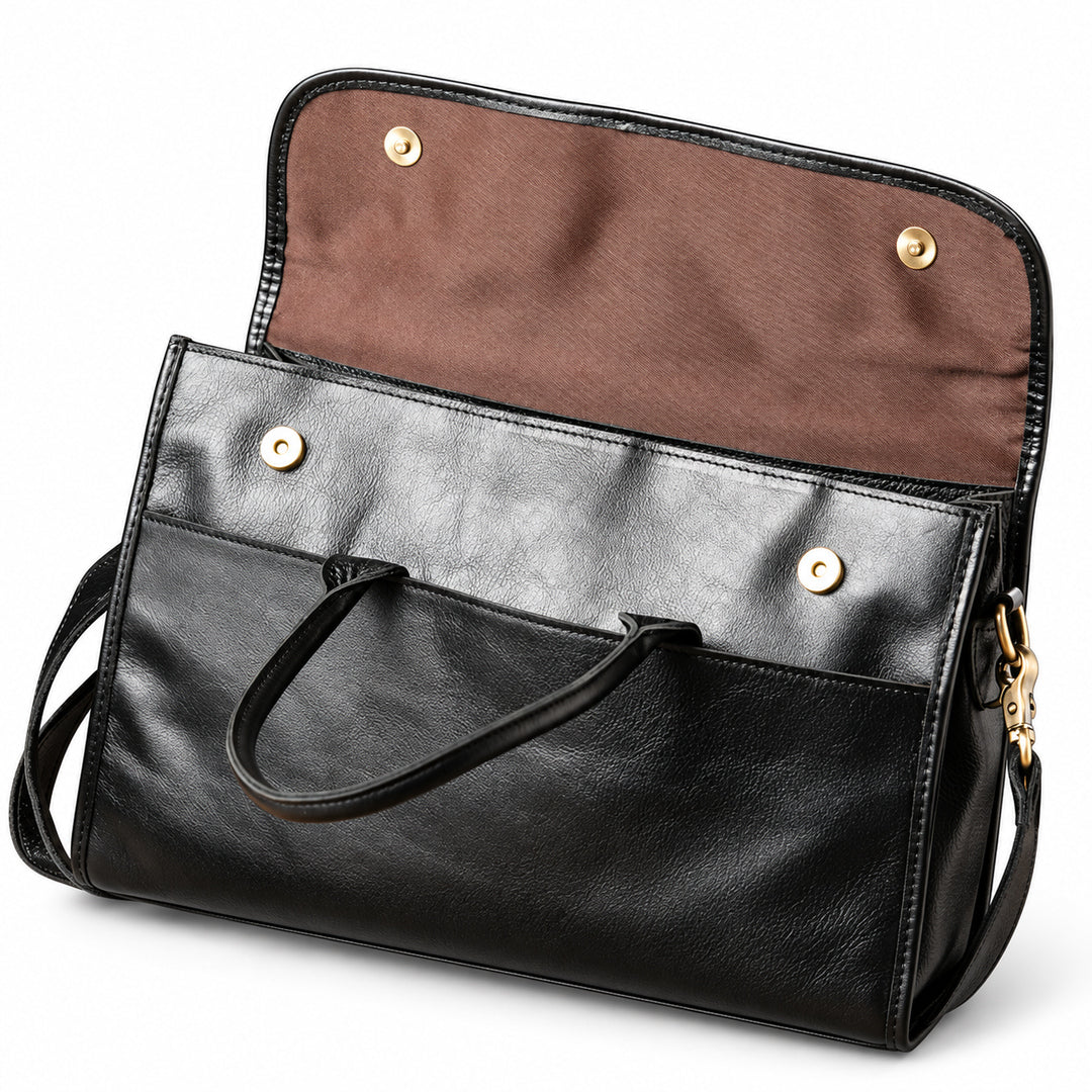The black full-grain leather briefcase has its flap lifted to reveal brown lining and two magnetic snap closures.