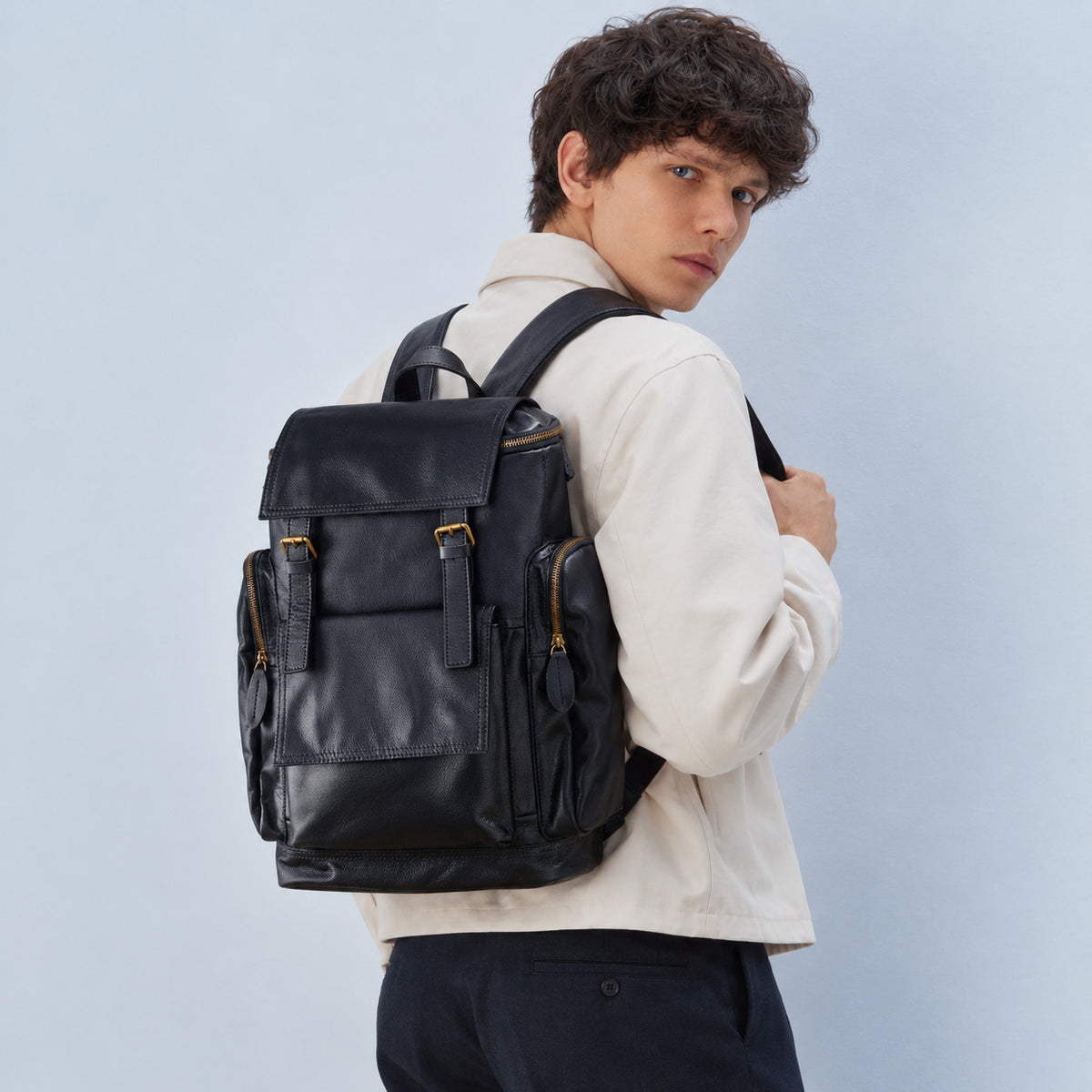 Spacious black leather backpack for men with flap top, buckle straps, large front pocket and zippered side pockets