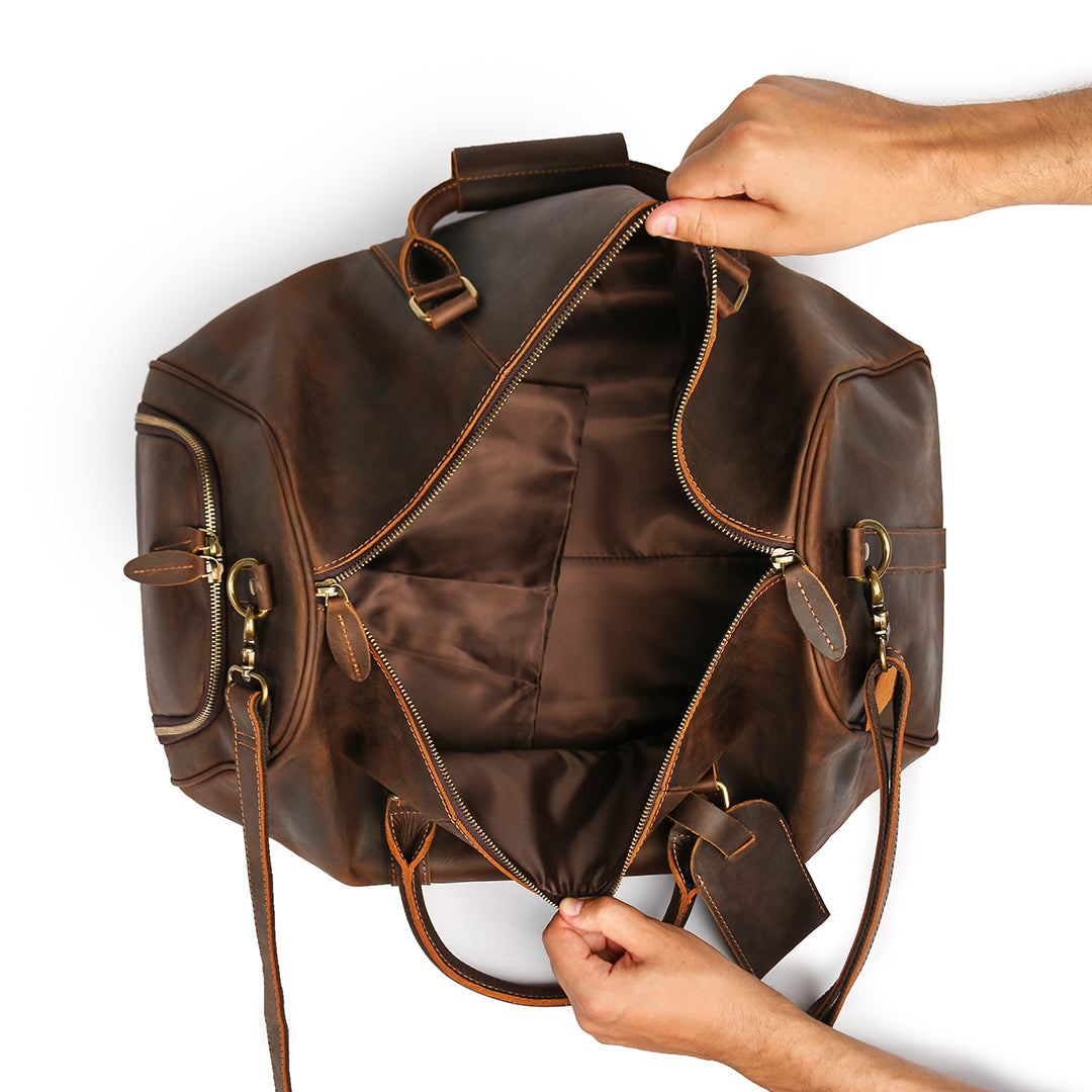 Spacious interior of a premium brown leather duffle bag with reinforced lining, ideal for travel essentials.
