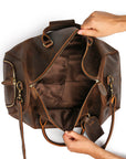 Spacious interior of a premium brown leather duffle bag with reinforced lining, ideal for travel essentials.
