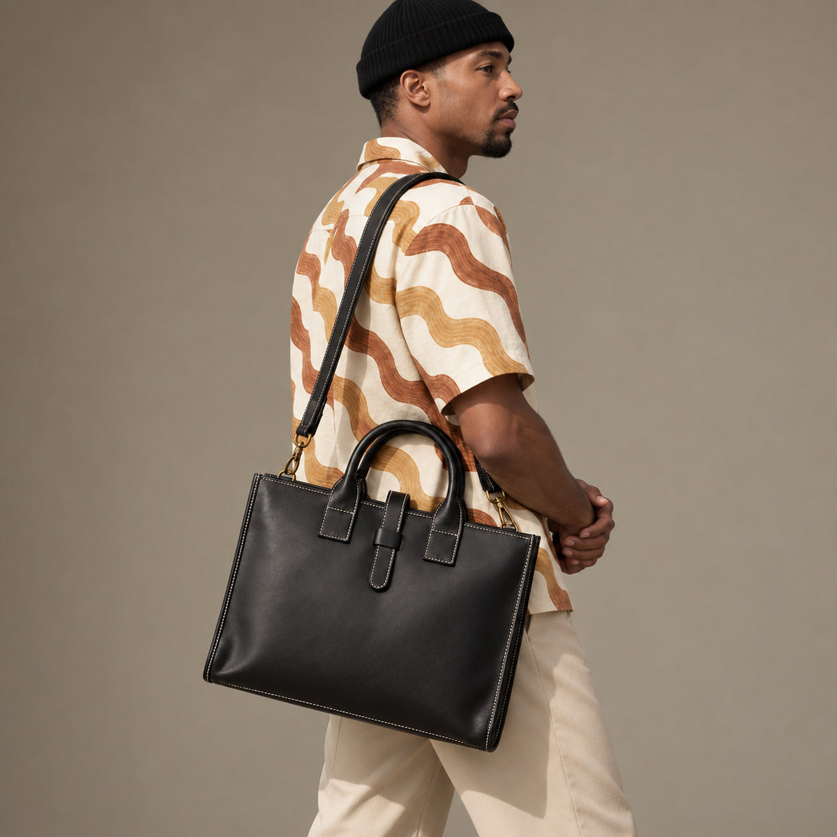 Structured black leather business bag for men with dual carry handles, contrast stitching and adjustable shoulder strap