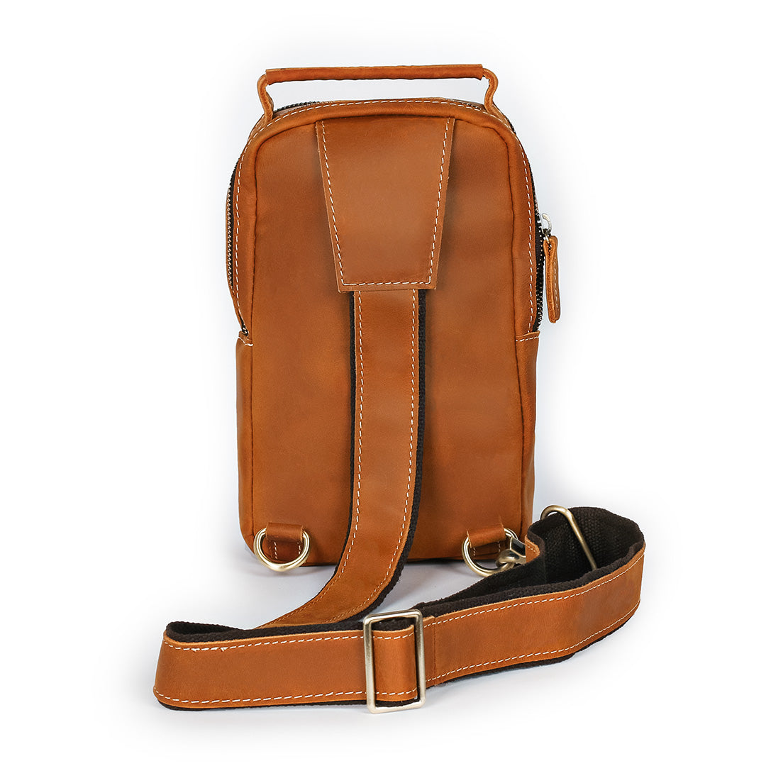 Tan leather sling bag back view with adjustable strap and durable stitching