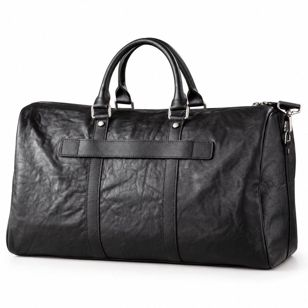 Textured black full-grain leather weekender bag at an angle showing the rounded side panel
