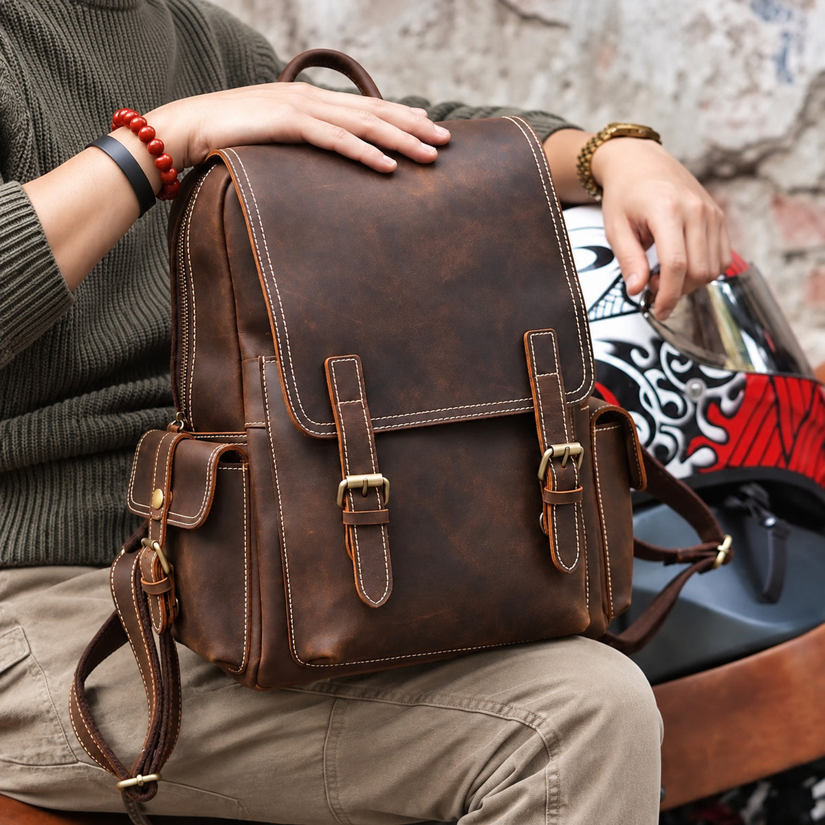 Vintage brown leather backpack for men with buckle straps, top handle and side pockets, front lifestyle view