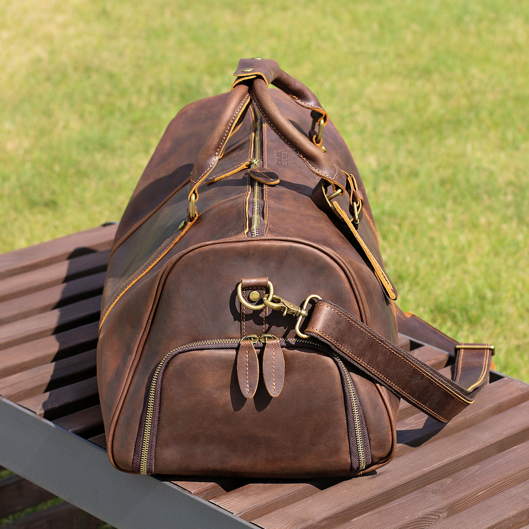 Side view of a vintage leather travel bag showcasing high-quality zippers and stitching details.